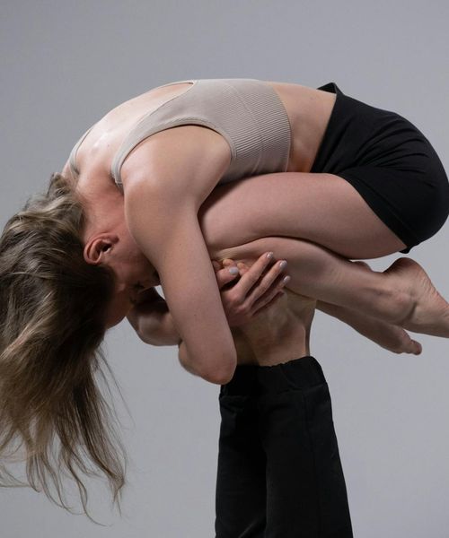 Man performing a controlled strength exercise in a minimalist studio.